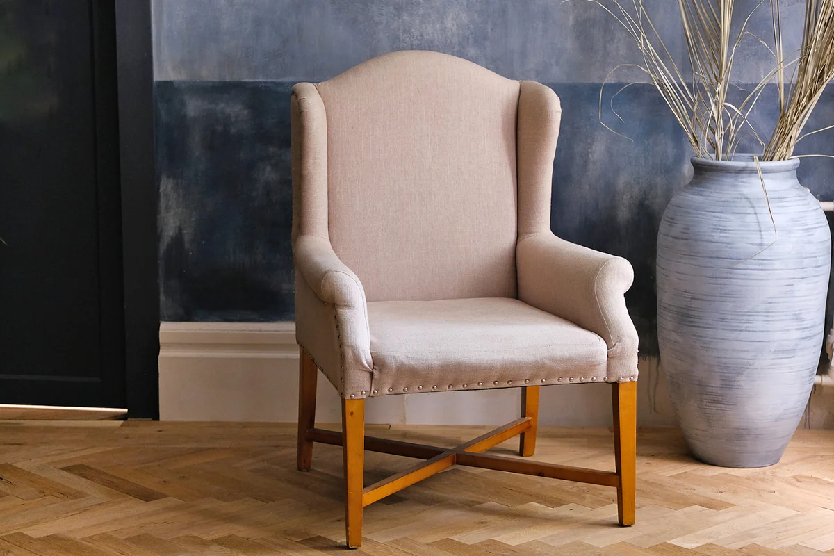 beige chair and a large vase on the floor