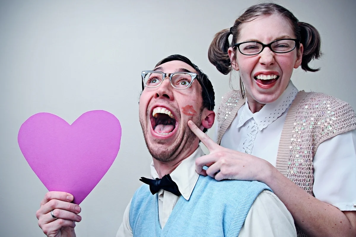 Cute Nerd Guy and Girl in Love Holding A Heart