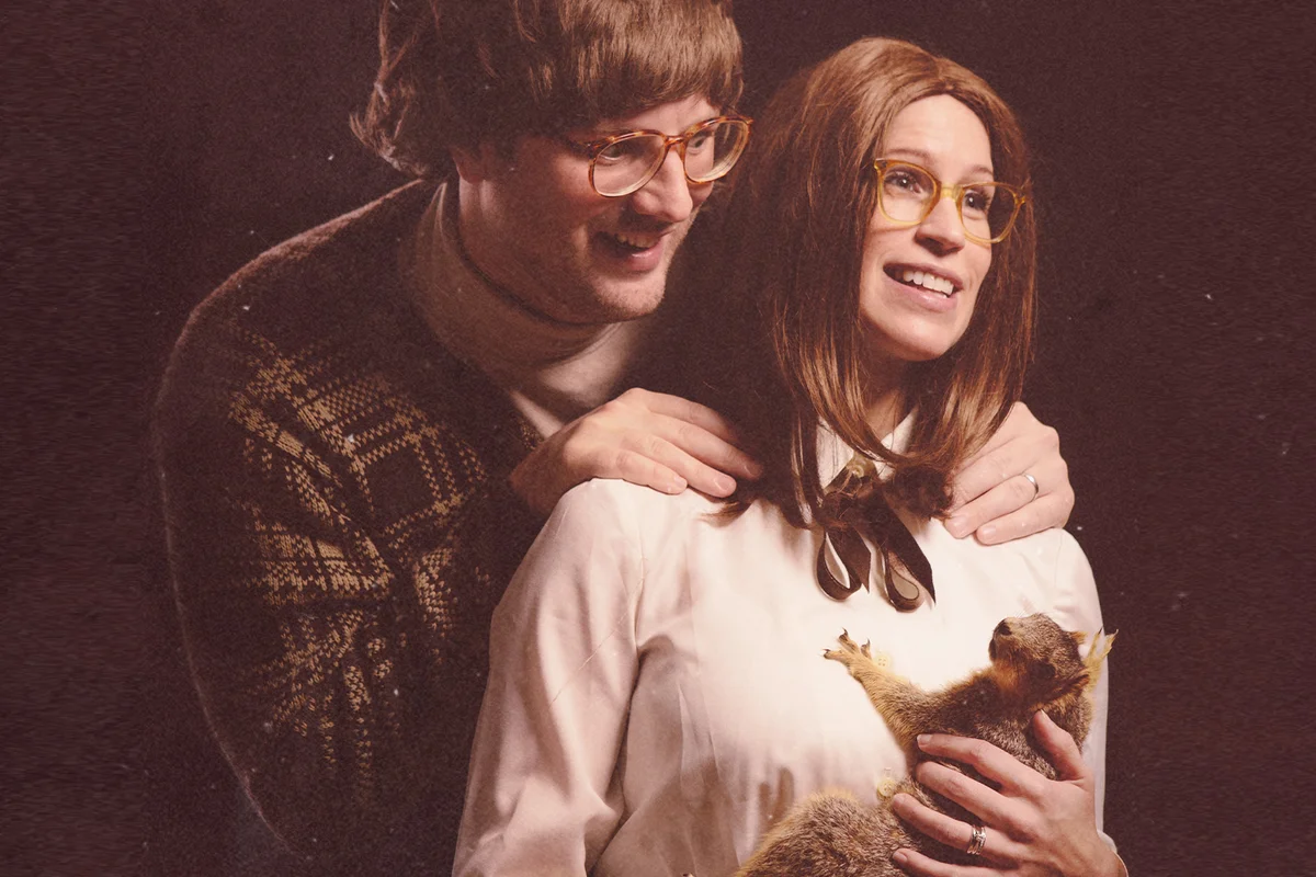 An awkward loving couple vintage style with stuffed squirrel like a baby