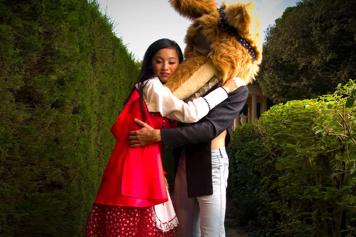 Woman Dressed as Red Riding Hood Hugging Wolf
