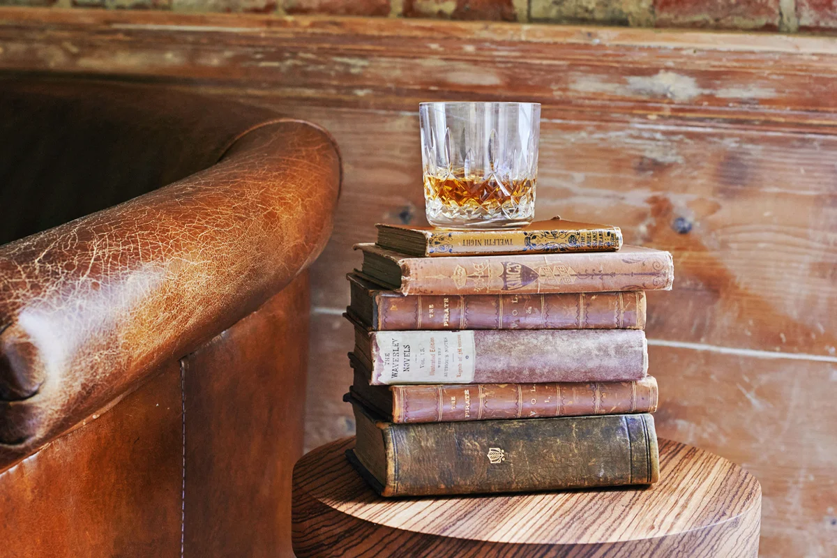 whiskey tumbler on antique books