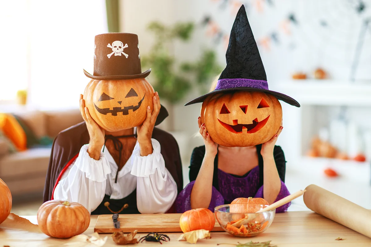 couple dressed as witches and vampires with pumpkins for heads