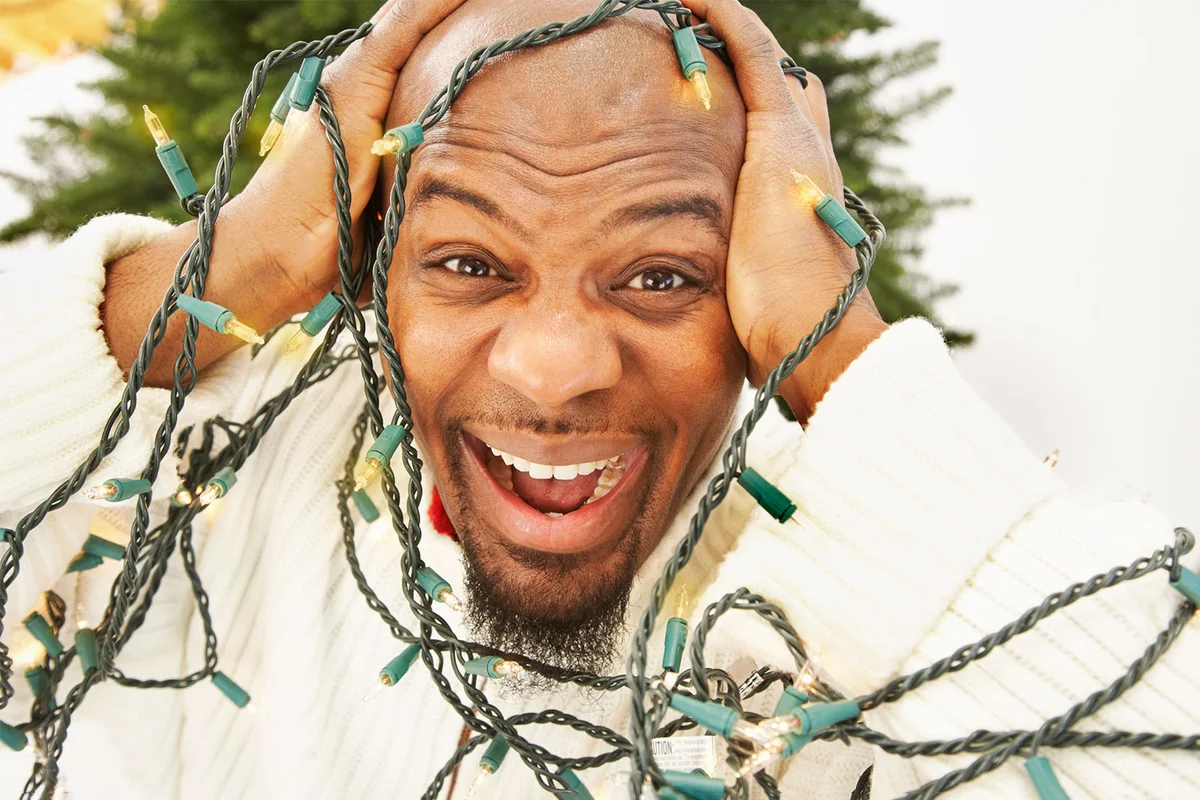 frustrated man with tangled Christmas lights
