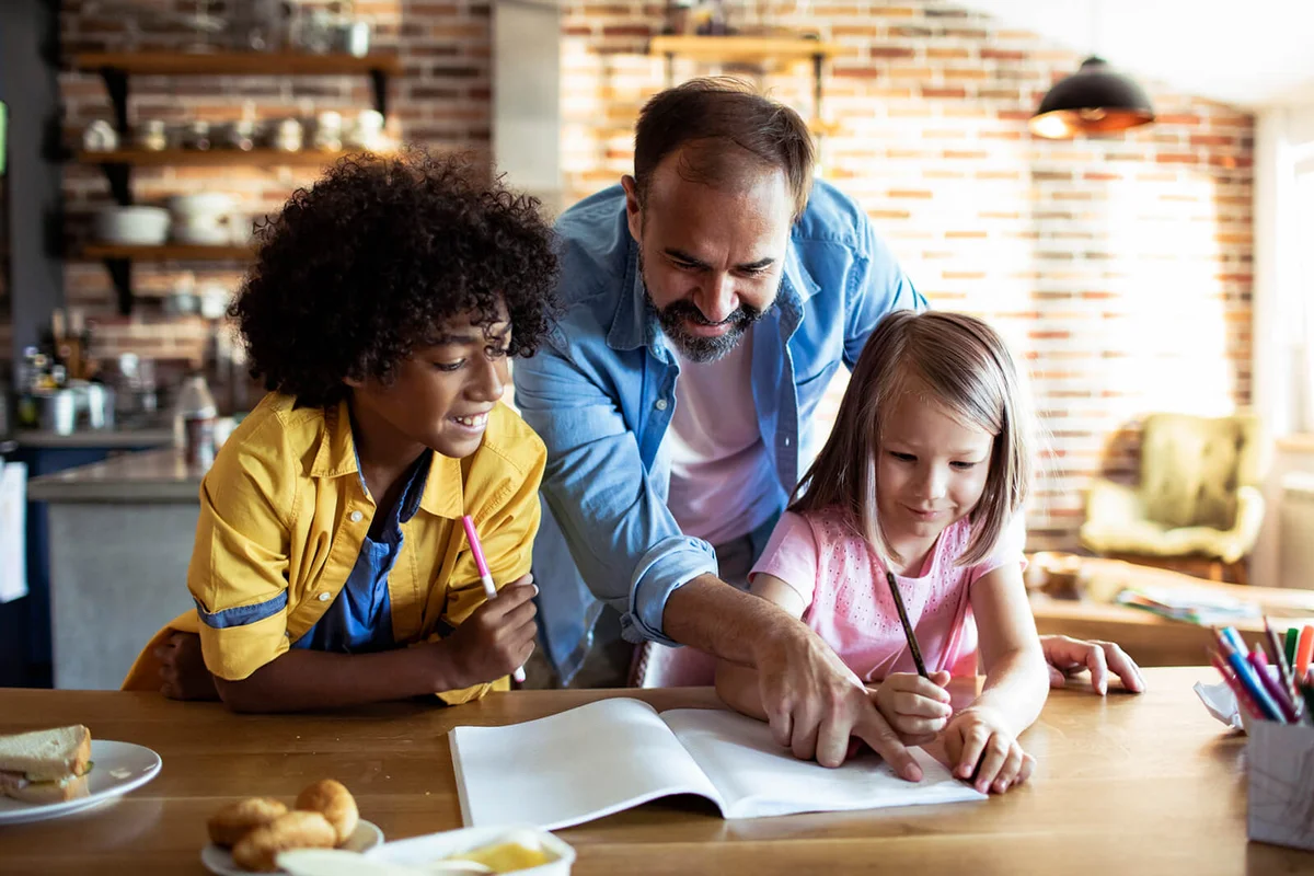 father helping his kids with school work