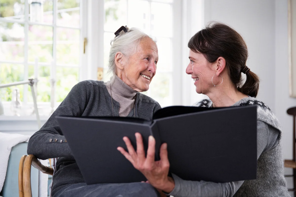 Two generation women looking in photo album together