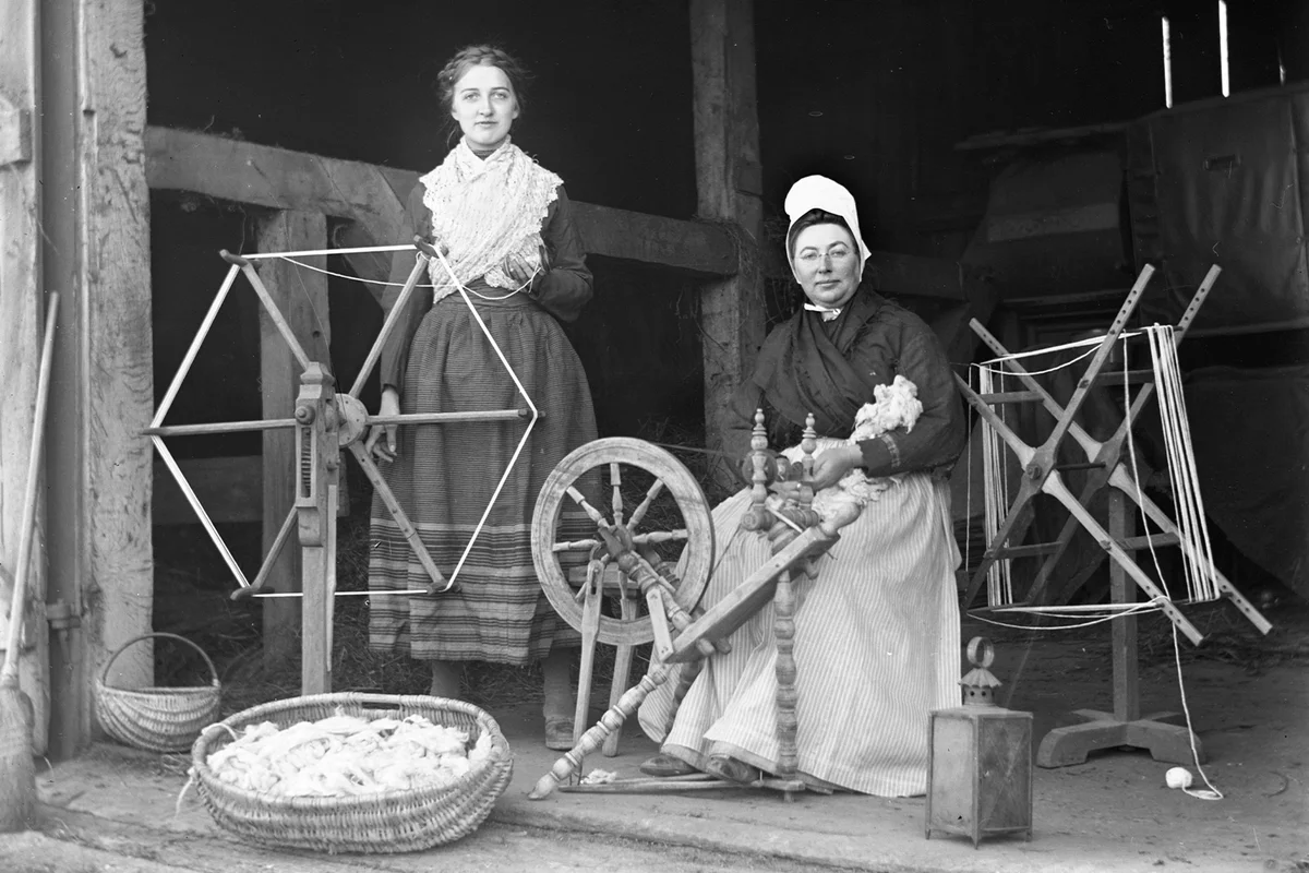 Two Women with a spinning wheel and a yarn winder