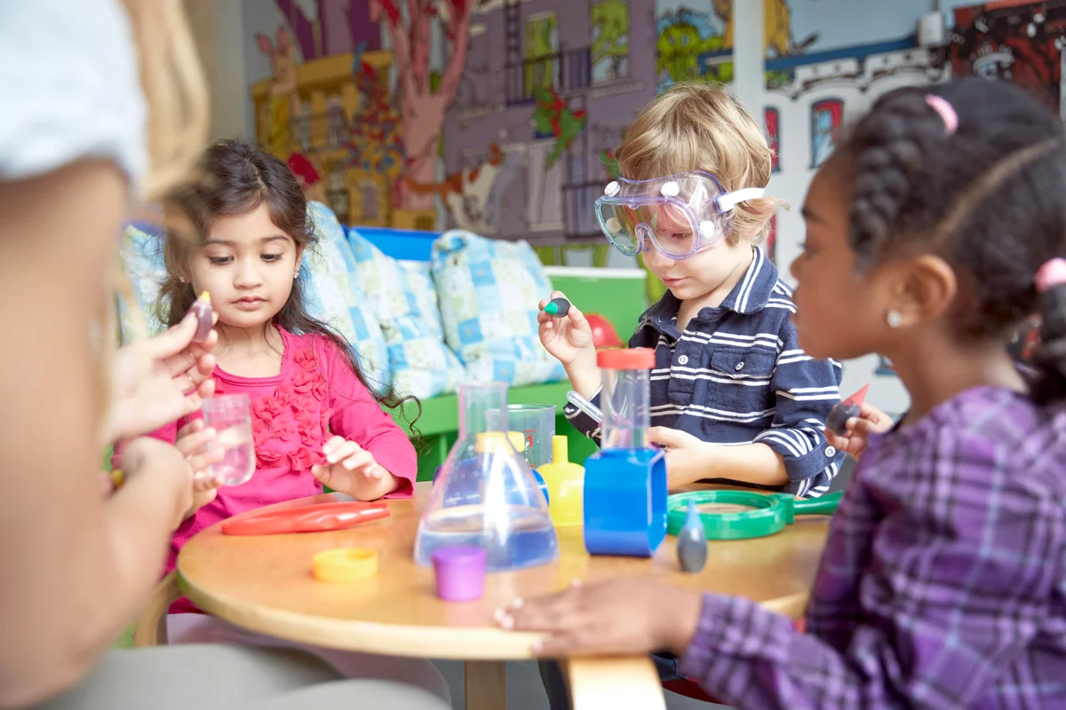 Children doing science experiment at table in preschool