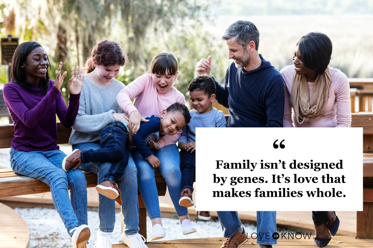 Blended family with five children sitting on park bench
