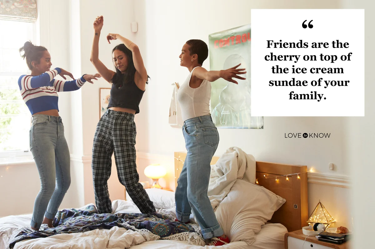 Cheerful young women dancing on bed at home