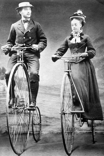Lady and gentleman riding ordinary bicycles with Starley wheels, 1874