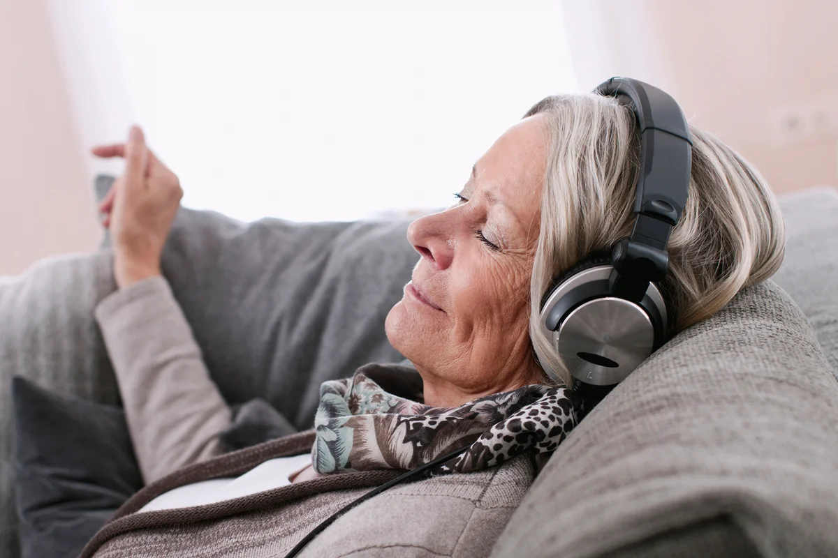 Senior woman listening music with headphones