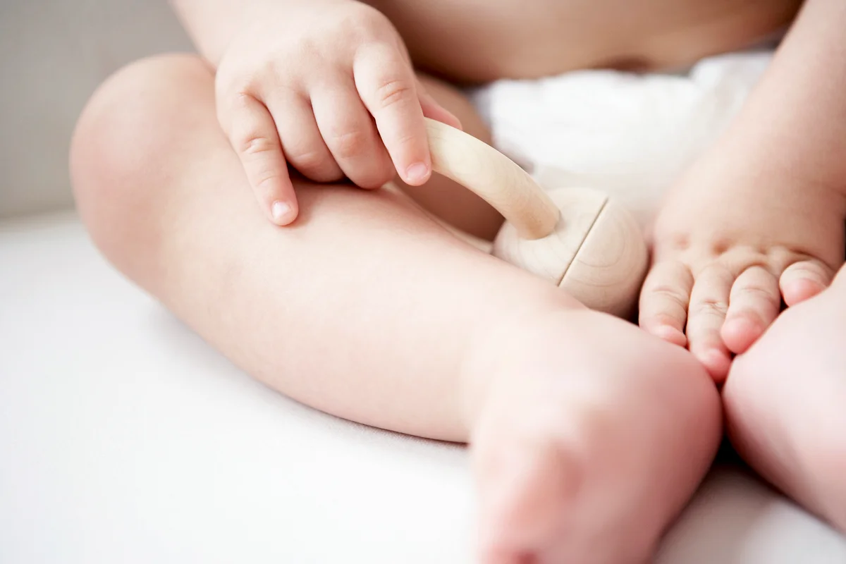Baby with Wooden Rattle