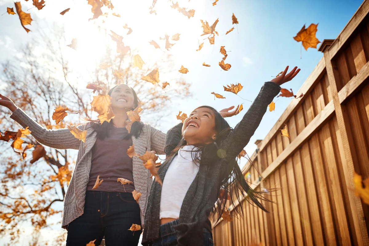 Adorable little girl and mom enjoying an autumn day outdoors