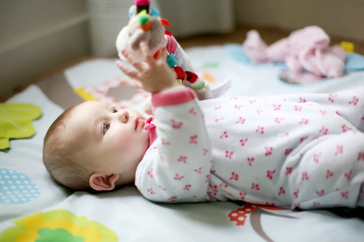 Baby girl observing a toy