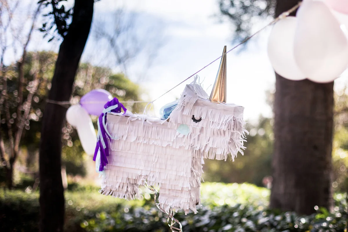 Unicorn homemade pinata hanging in the park
