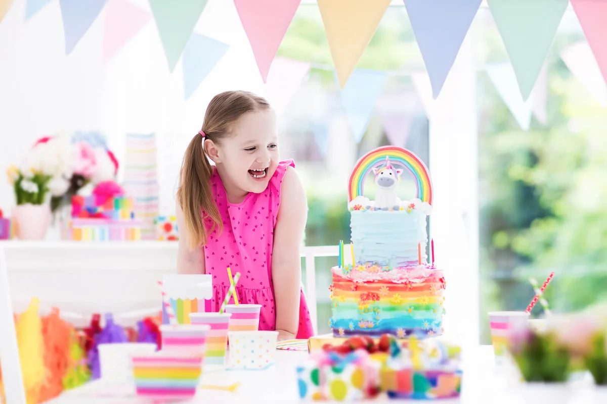 Kids birthday party with colorful pastel decoration and unicorn rainbow cake