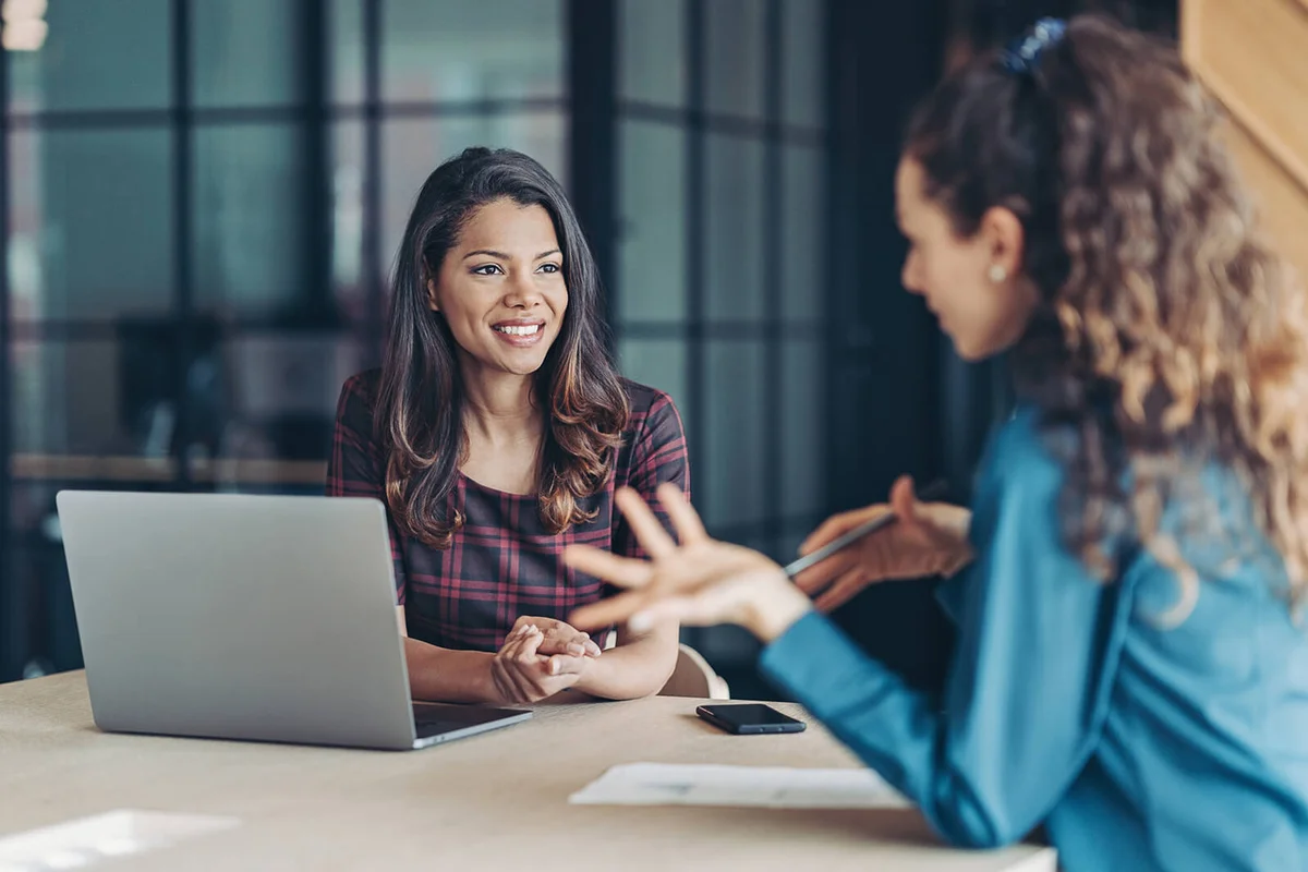 Two young women discussing business