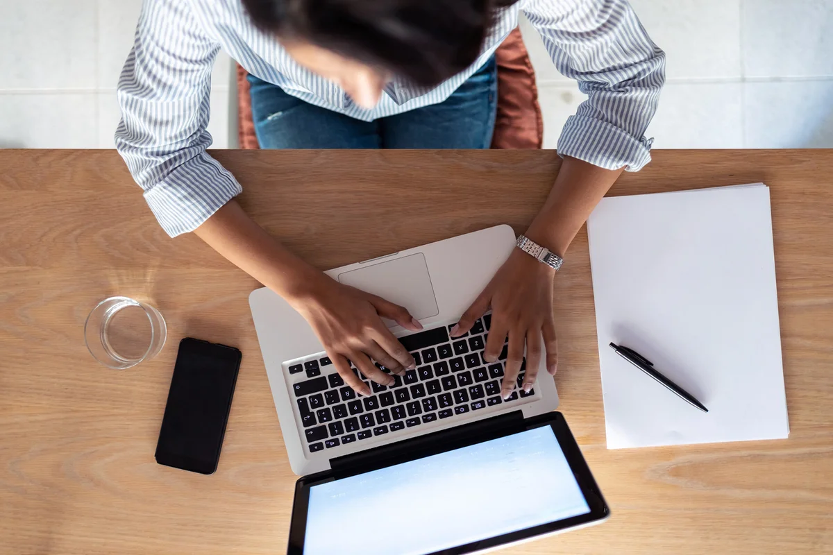 Elegant young business woman working with her laptop in the office. Top view.