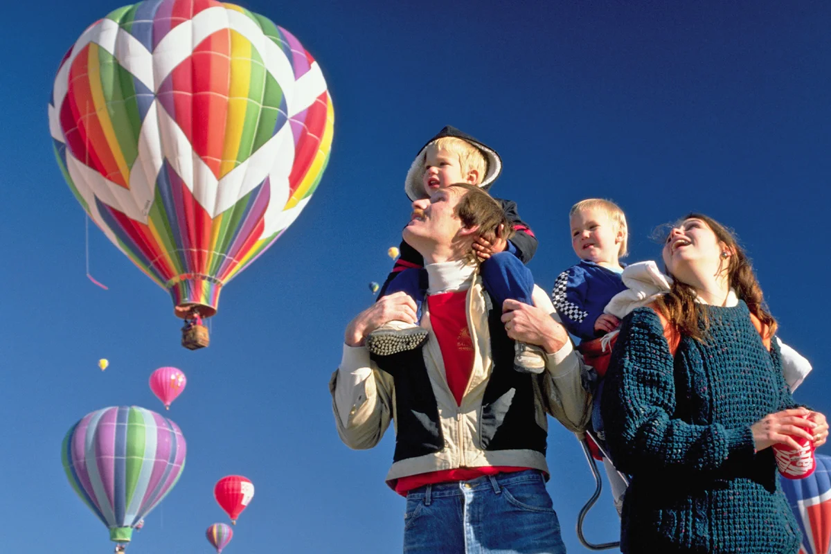Family Watching Colorful Hot Air Balloons