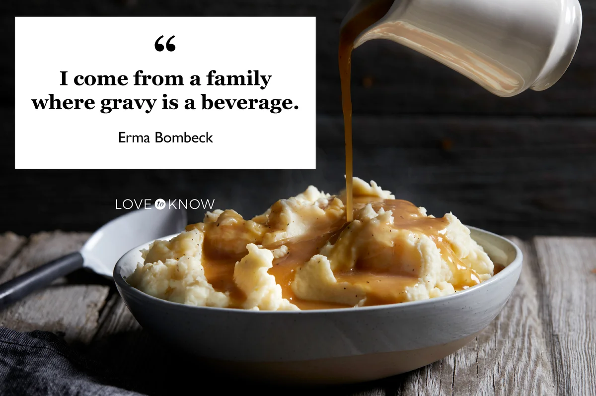 Jug of gravy being poured onto bowl of steaming mashed potatoes