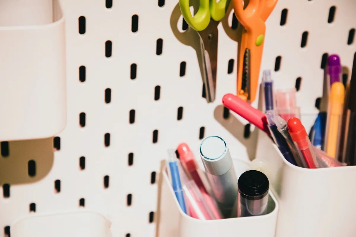 scissors and color pens hanging on the pegboard