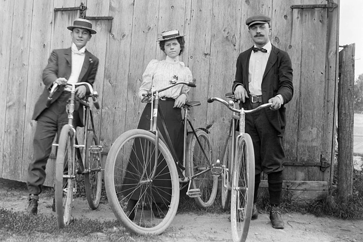 Lady bicyclist surrounded by two gents. Photograph, ca 1900. | Getty Editorial Use