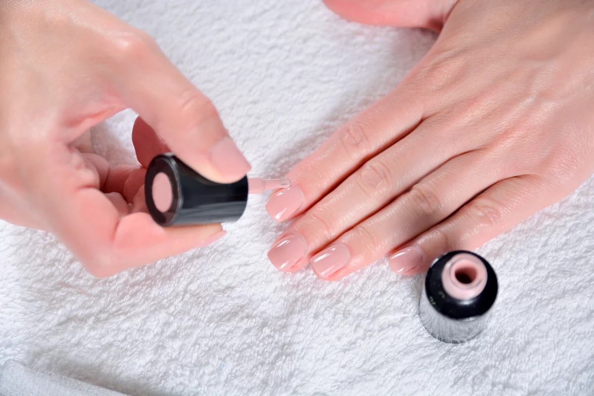Woman hand and nails colored in nude natural color