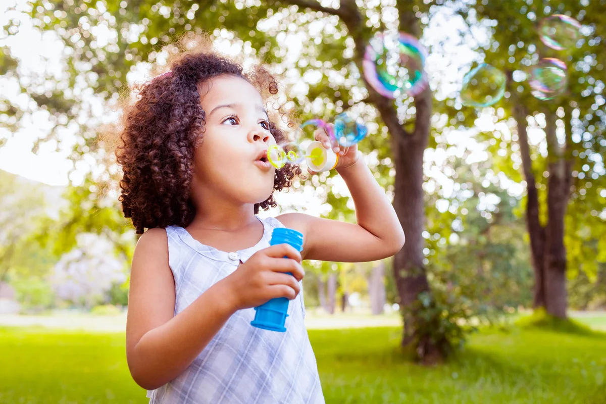 toddler girl blowing bubbles
