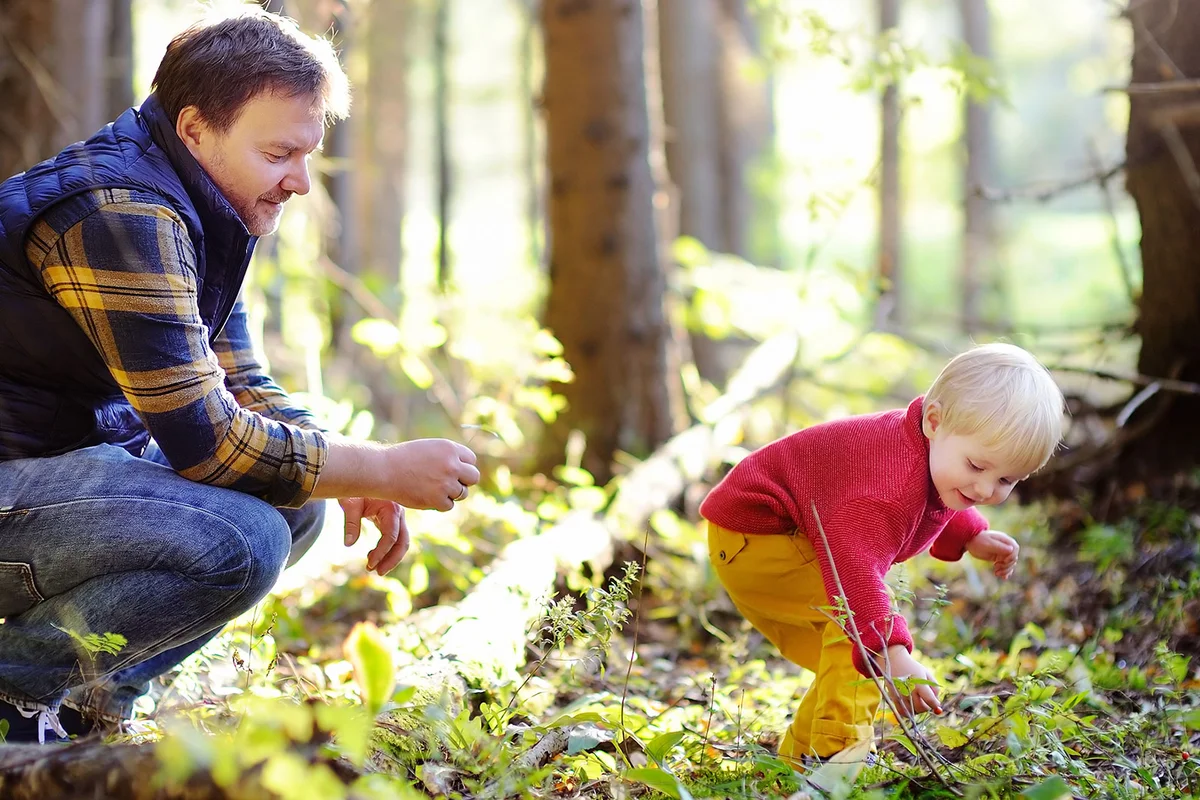 father and toddler son exploring nature