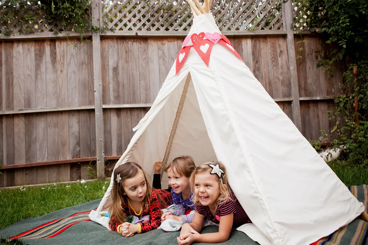 toddlers in tent camping in backyard