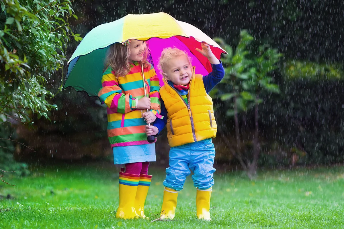 toddlers under an umbrella in rain