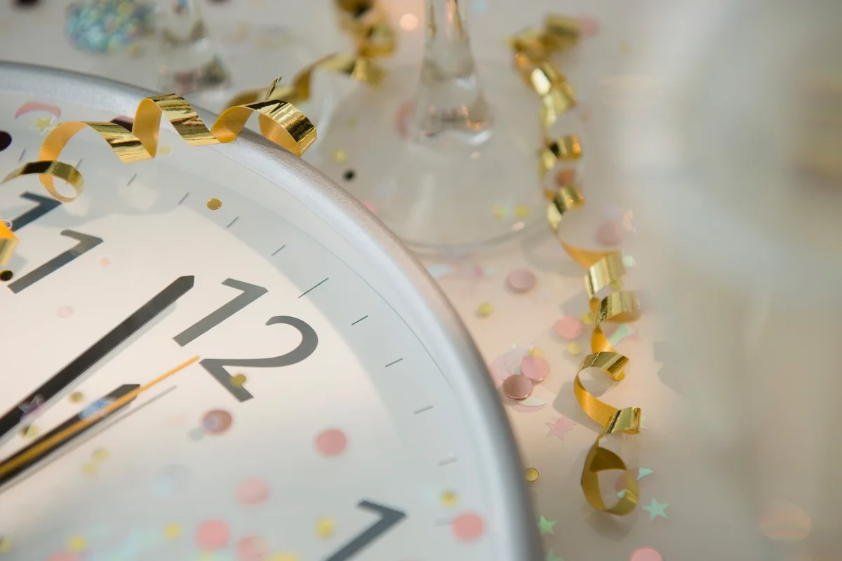 12 o'clock on clock decorated with confetti and streamer