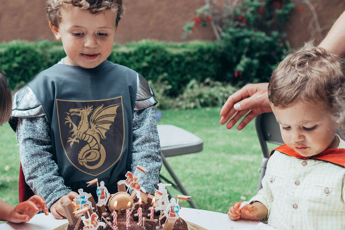 boy in knight costume with birthday cake
