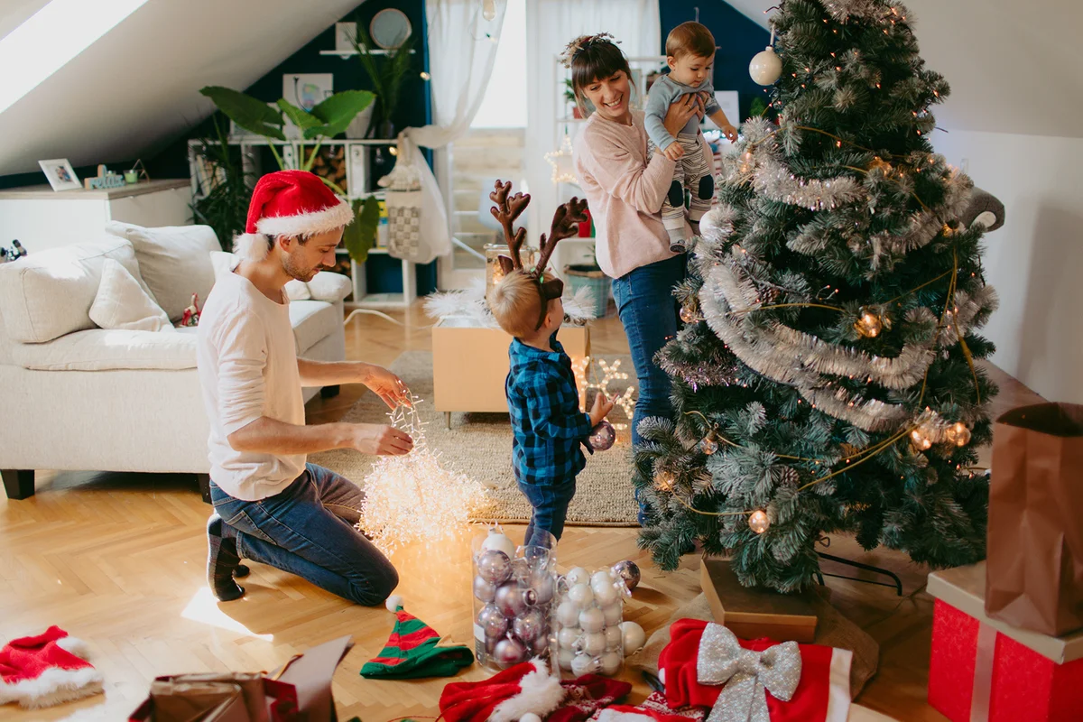 family with two children, decorating Christmas tree