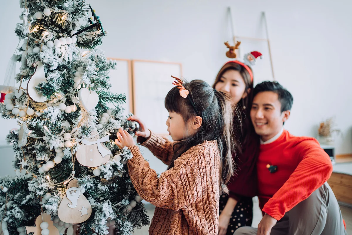 Happy family decorating Christmas tree together