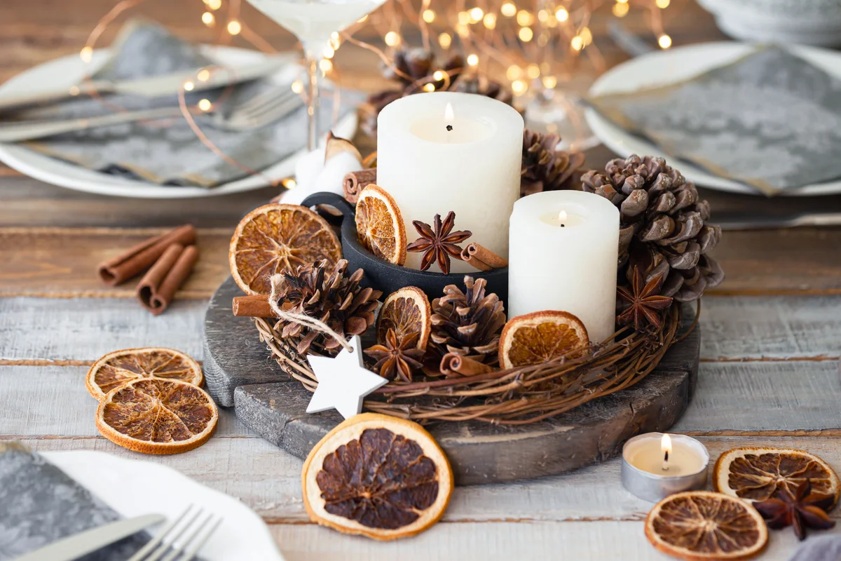 Center piece with white candle, dry orange, cones and cotton