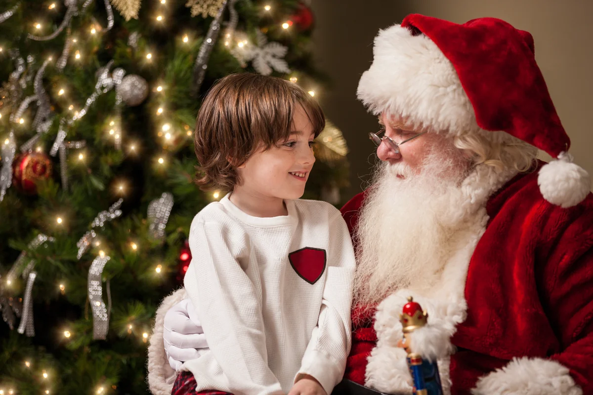 boy sitting on Santa's lap talking
