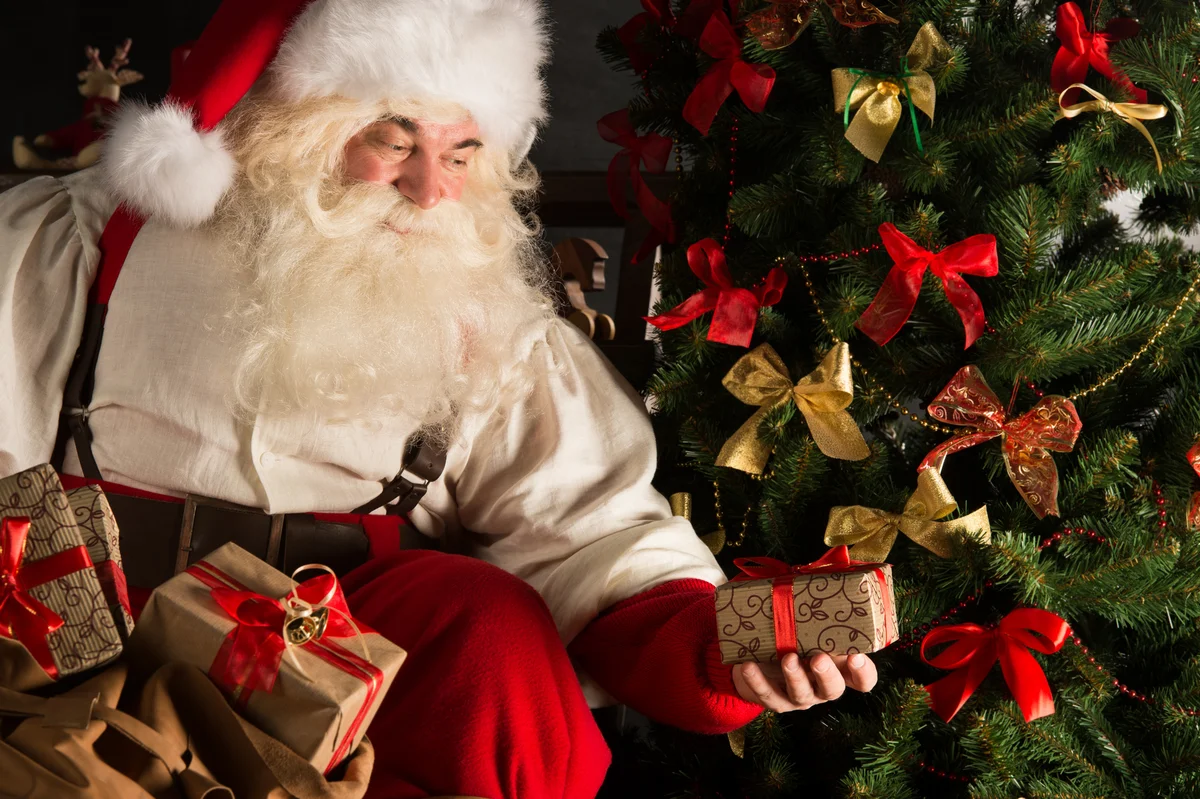 santa delivering gifts under tree