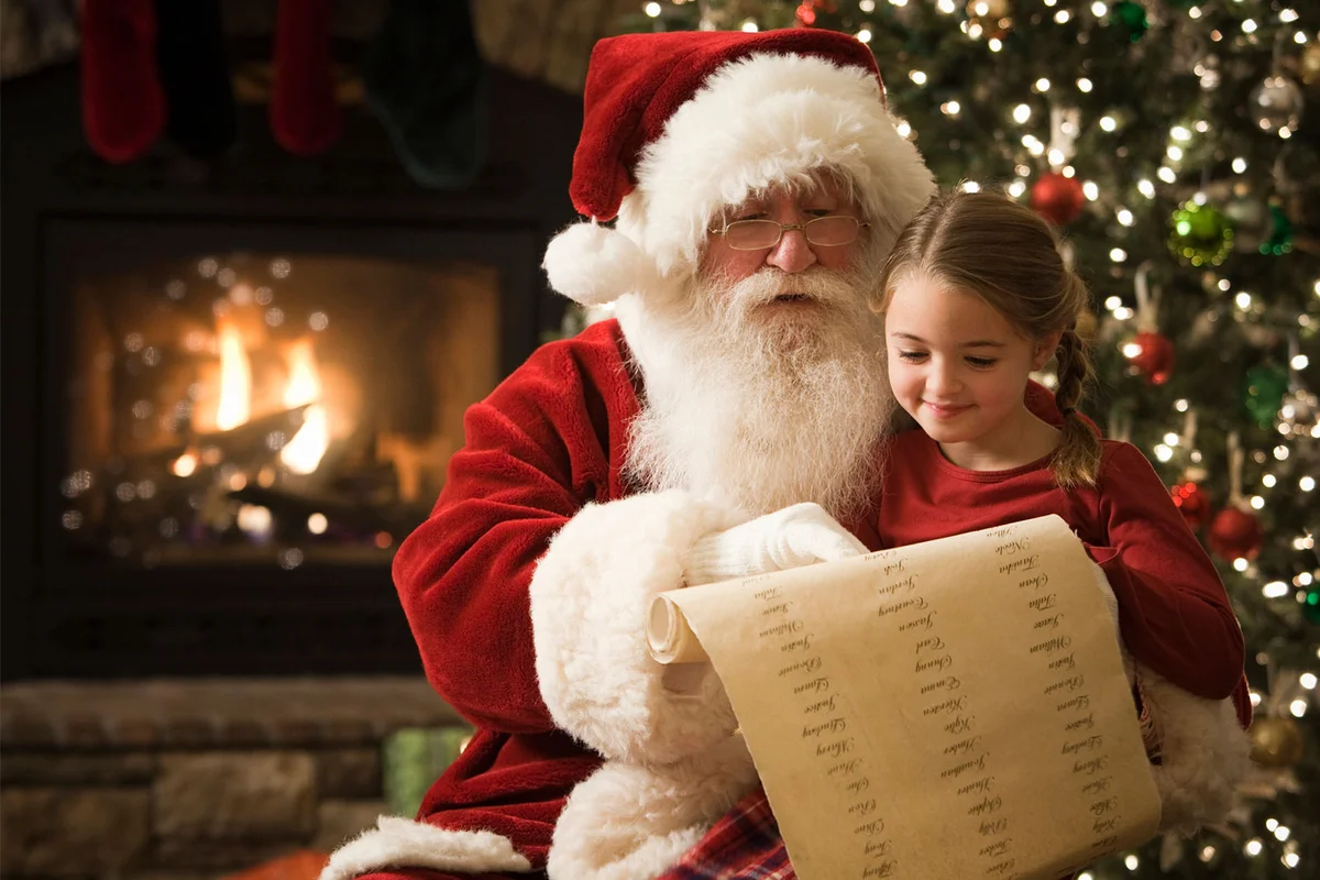 Santa reading list with girl at Christmas