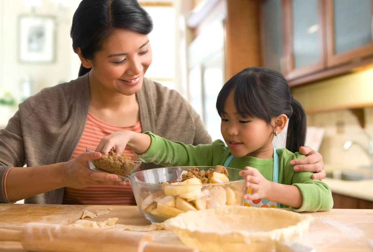 mother and daughter baking an apple pie