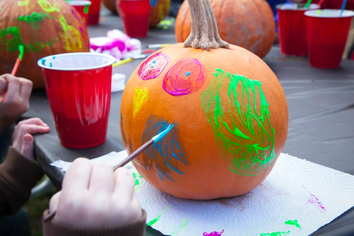child painting a pumpkin