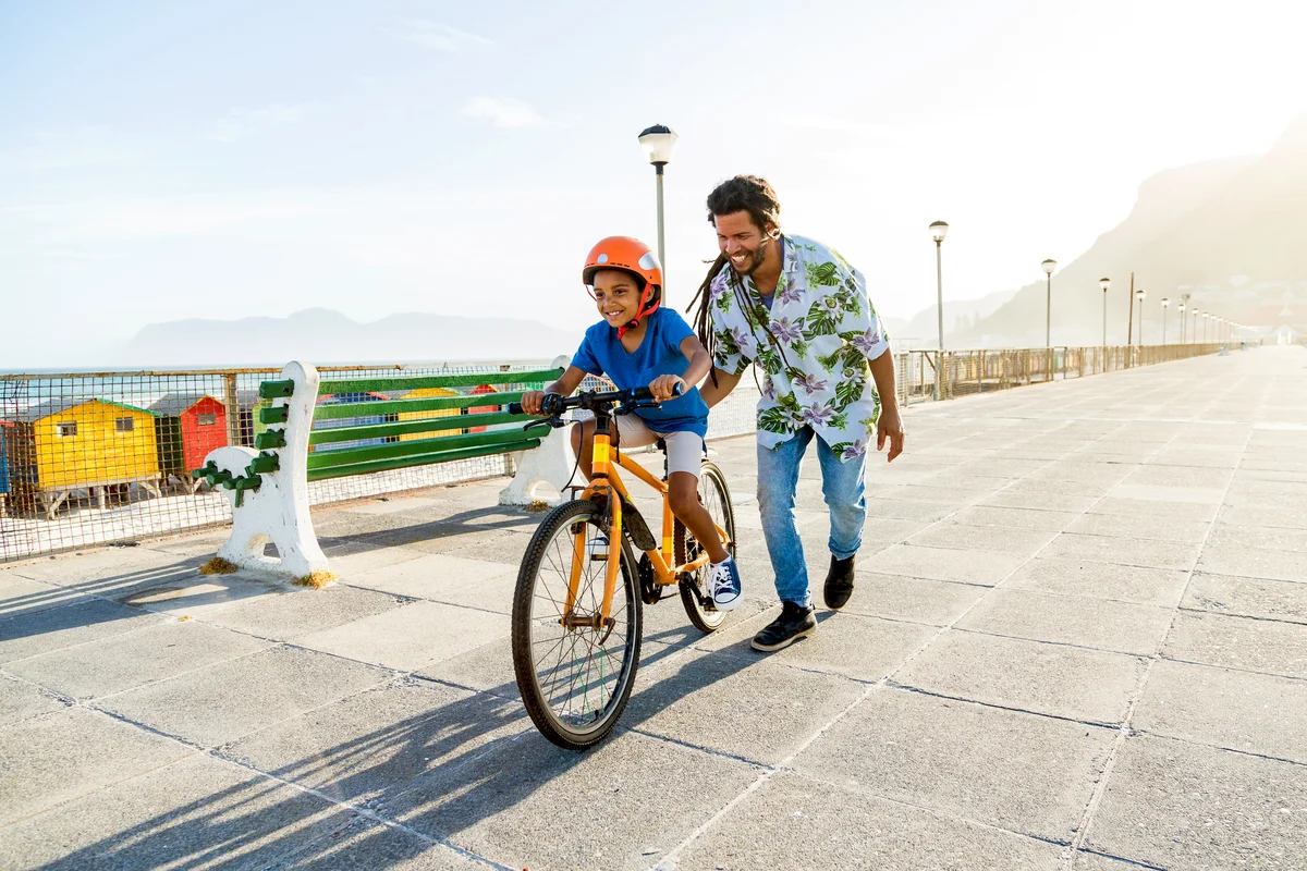 Boy riding a bike with his dad