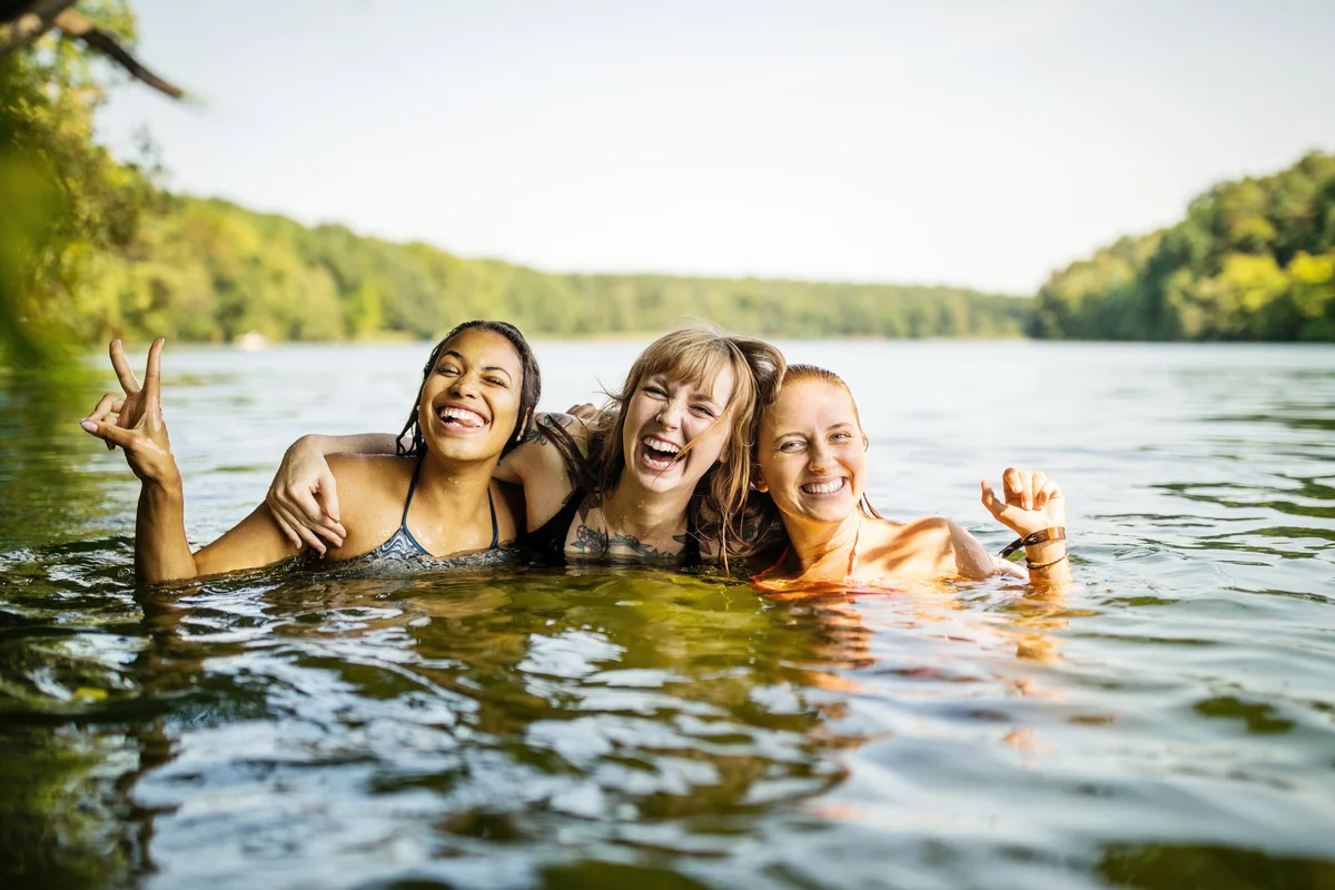 Portrait of three young women together in lake