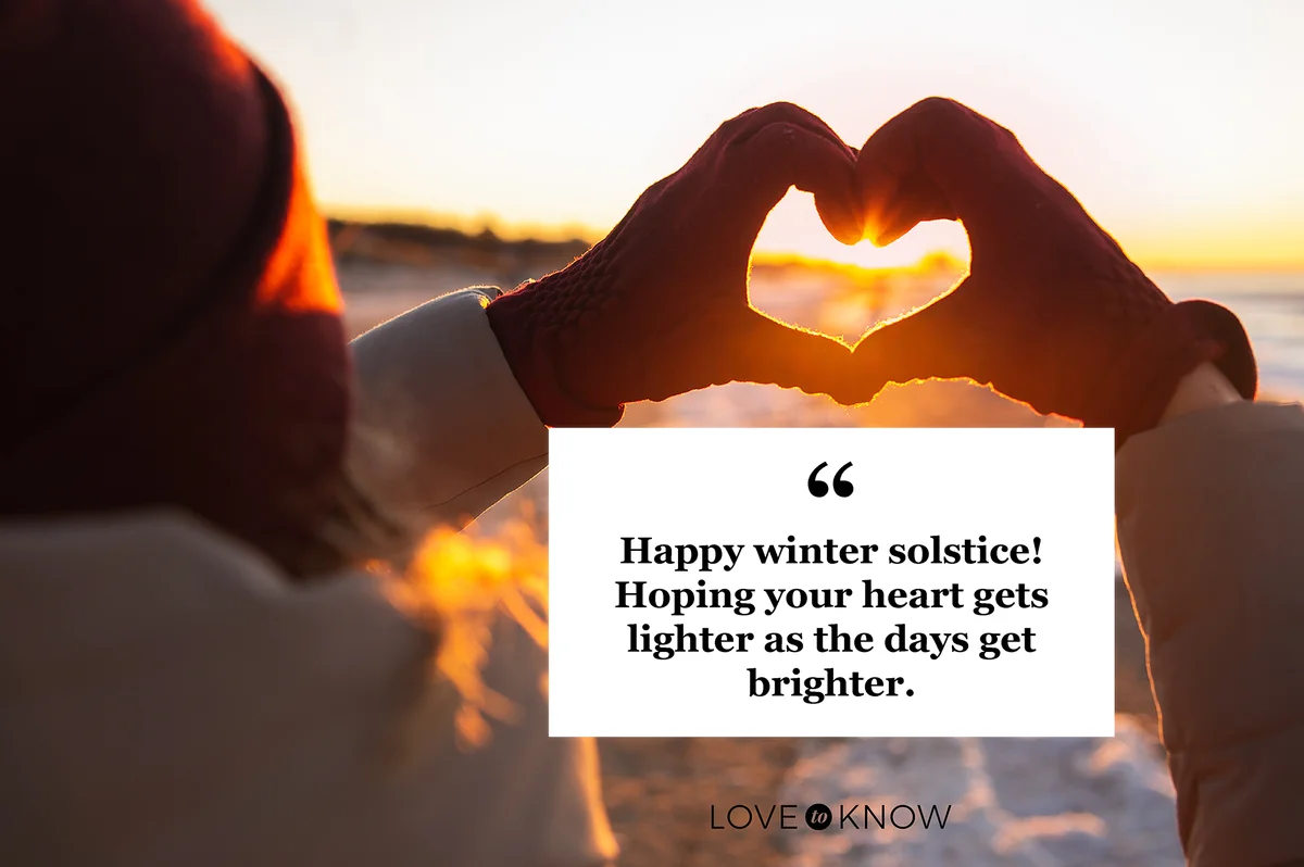 Woman hands in red winter gloves heart symbol shaped at winter solstice