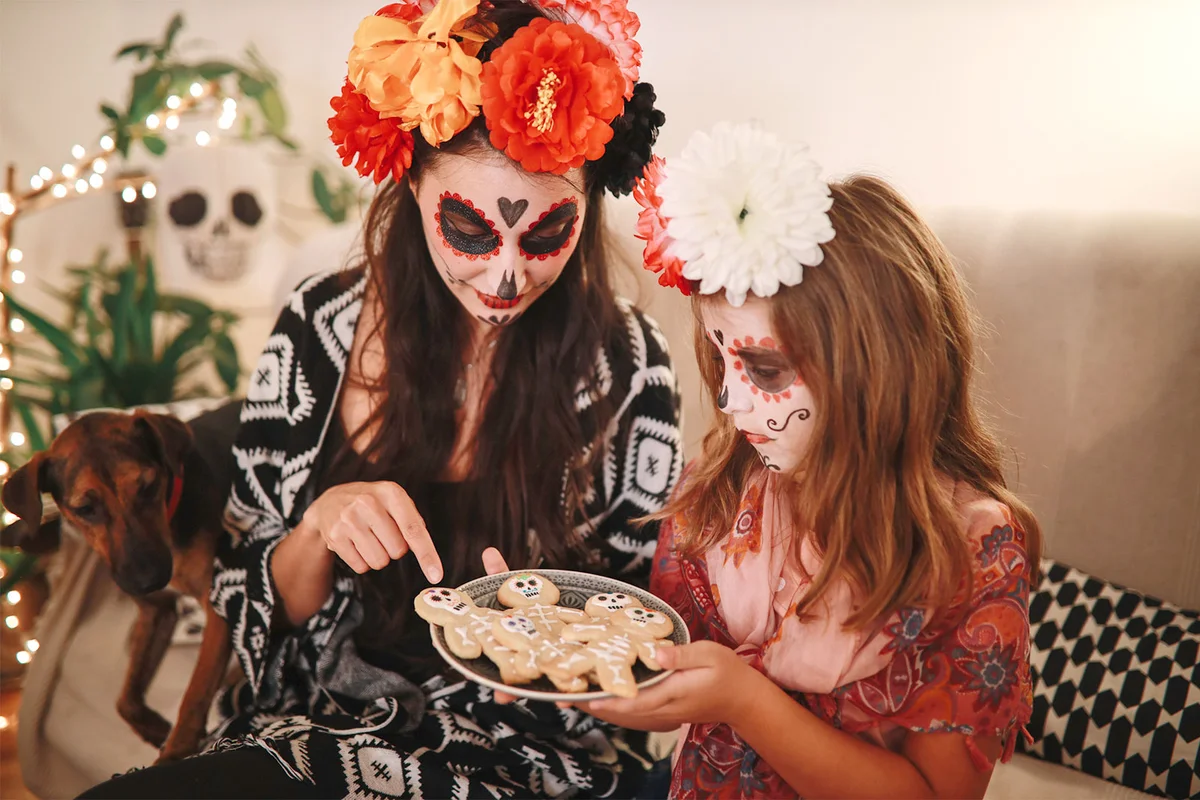 mother teaching daughter about div de los muertos