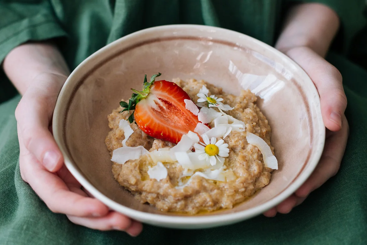 bowl of slow cooker oatmeal with strawberry and coconut topping