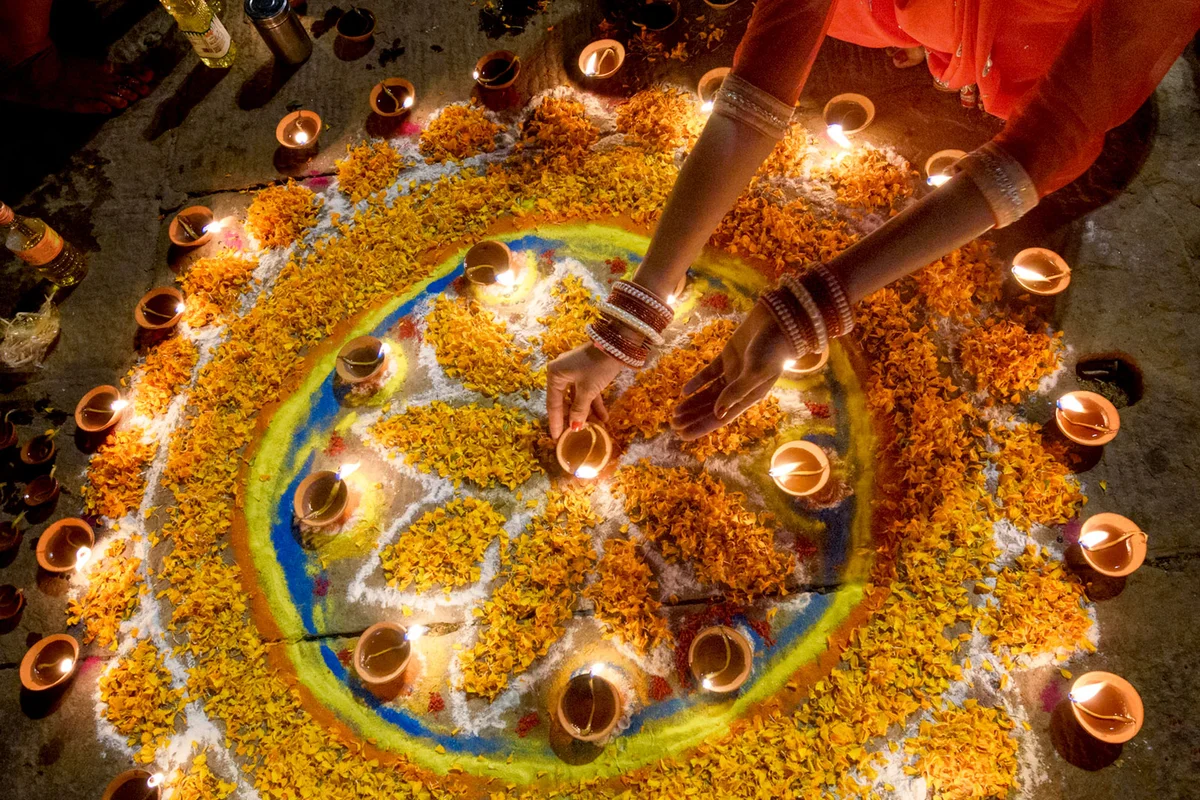 woman lighting diyas during diwali