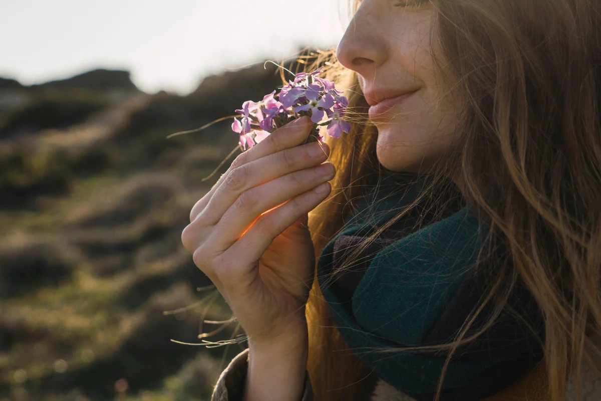 Woman enjoying fragrance of a flower