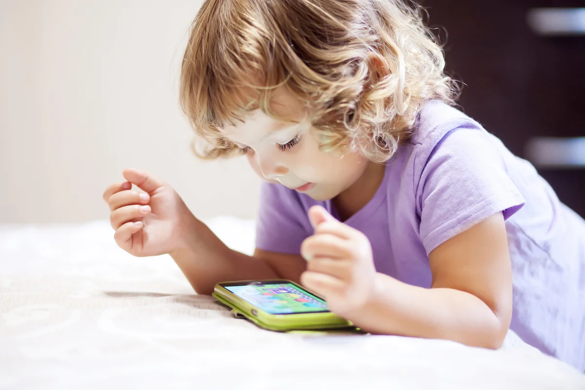 Cute little girl playing with smartphone