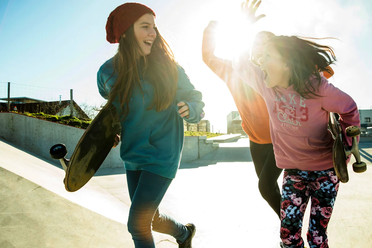 Three sisters running in skatepark